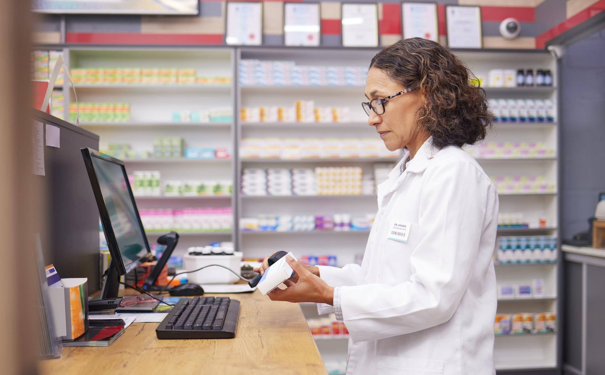 Farmaceútica escaneando medicamentos en una farmacia.
